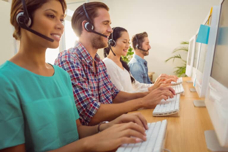 Non-clinical staff working at computers with headsets