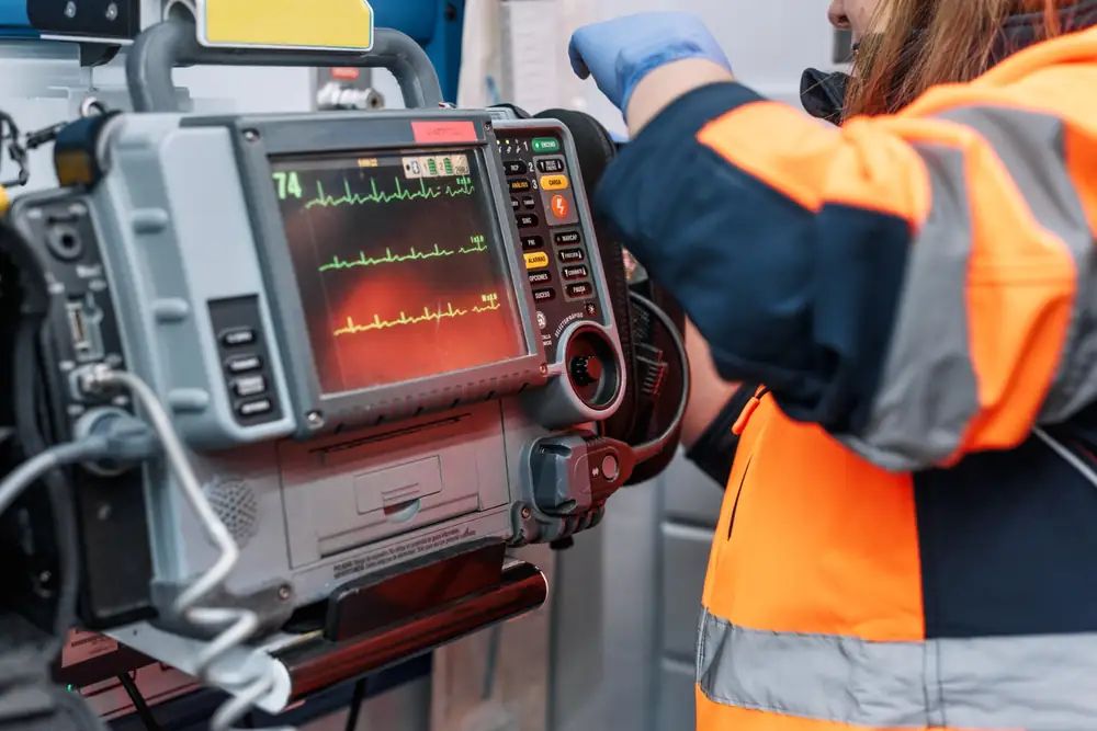 MICU critical care paramedic working at a cardiac monitor in an ambulance