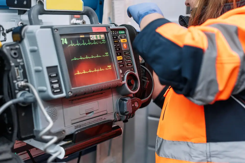 MICU critical care paramedic working at a cardiac monitor in an ambulance