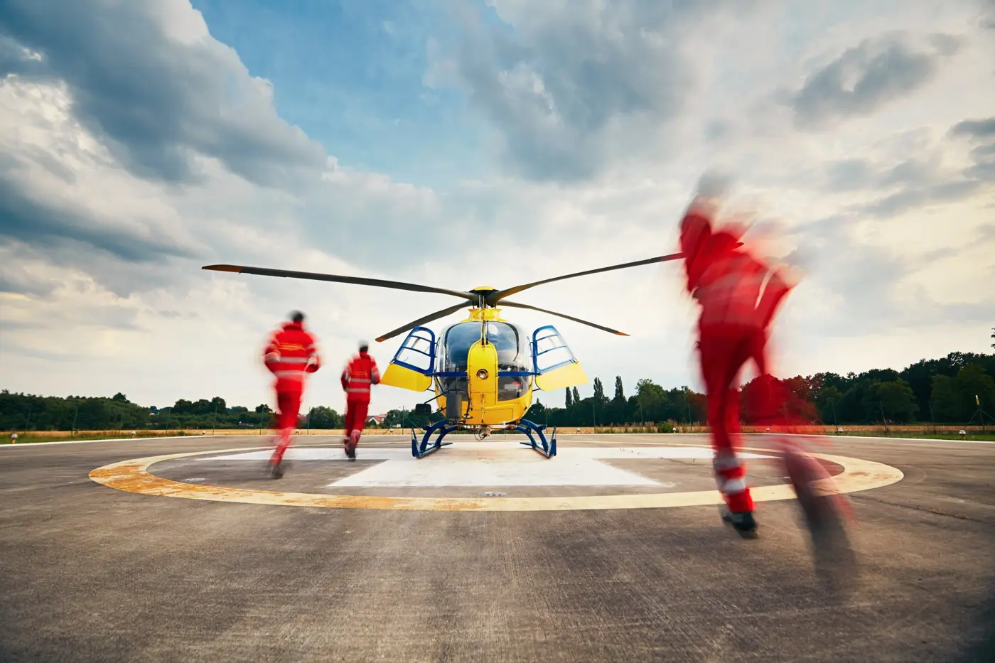 Flight paramedics running to an air ambulance helicopter on a helipad